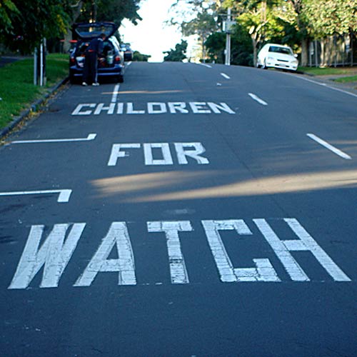 Children for watch painted road sign sign in Mt Eden, Auckland, photographed by Angle Limited